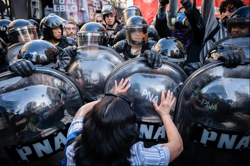 BUENOS AIRES, ARGENTINA - 2024/09/04: A woman stops the advancing police during the protest. Groups of retirees and pensioners protested outside the National Congress, as they do every Wednesday, against the presidential veto of the pension reform and Javier Milei's economic policies. Police enforced the anti-picketing protocol, using tear gas to disperse the demonstrators. The protesters voiced strong opposition to the government's economic adjustments and the veto, which they believe harms their rights. The clashes highlight ongoing tensions between retirees and the current istration. (Photo by Santiago Oroz/SOPA Images/LightRocket via Getty Images)